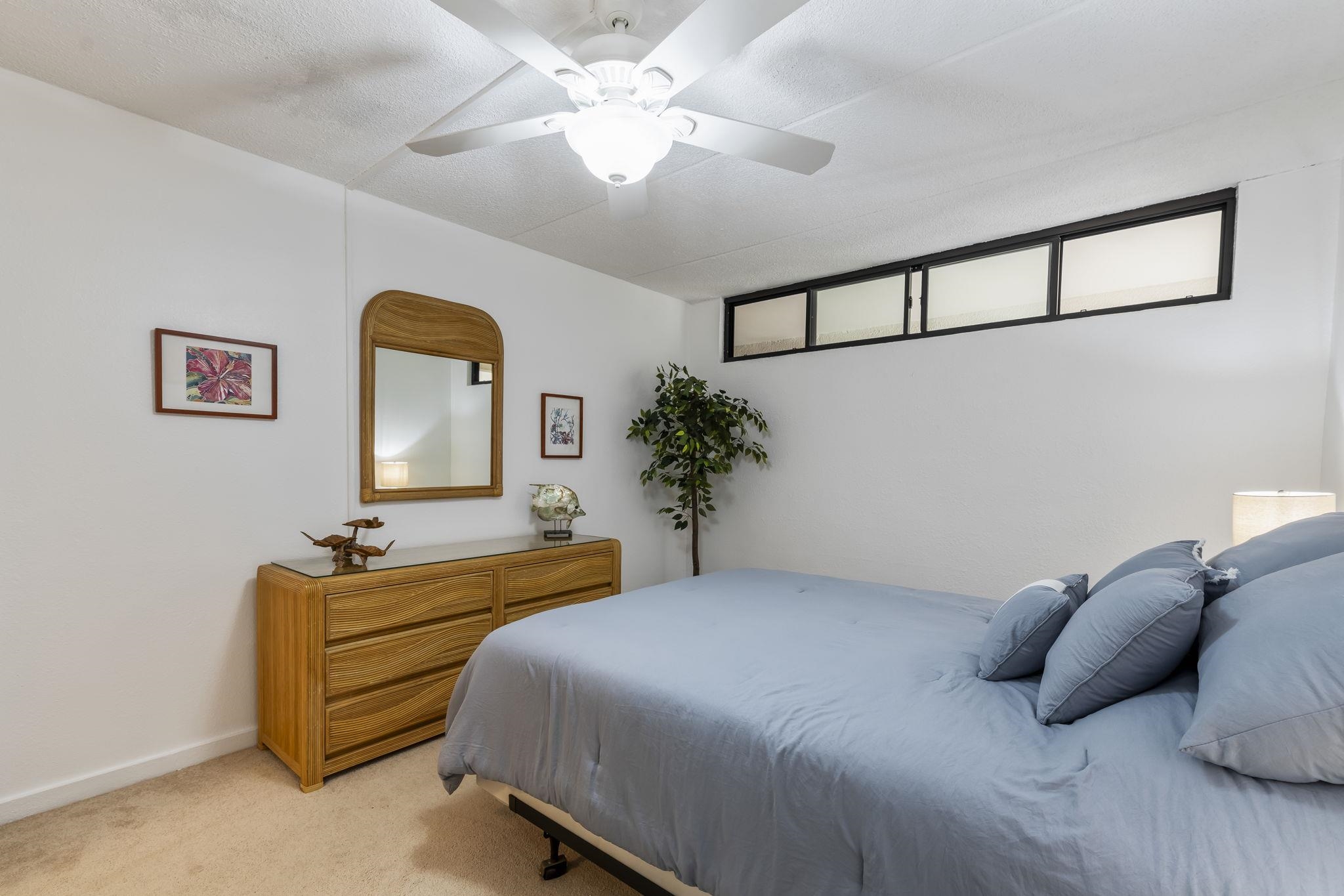 2531 South Kihei Road, Unit DG10 Kihei, HI 96753 - Photo 13 of 31 a bedroom with a bed and a chandelier
