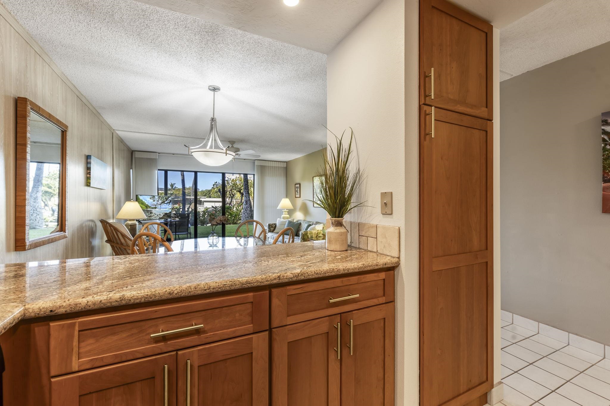 2531 South Kihei Road, Unit DG10 Kihei, HI 96753 - Photo 17 of 31 a kitchen with granite countertop stainless steel appliances and wooden cabinets