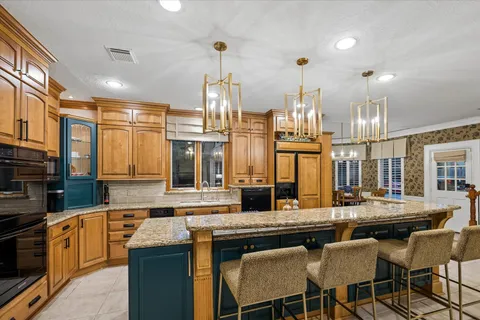 a kitchen with stainless steel appliances granite countertop a sink and a stove