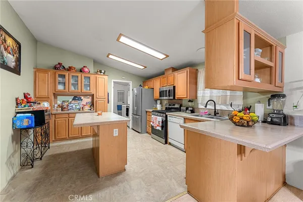 a kitchen that has a lot of cabinets in it and appliances