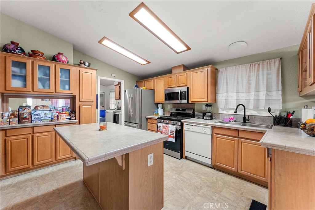 138 Sir Damas Drive Riverside, CA 92507 - Photo 19 of 36 a open kitchen with stainless steel appliances granite countertop a stove top oven a sink dishwasher and a refrigerator with wooden cabinets