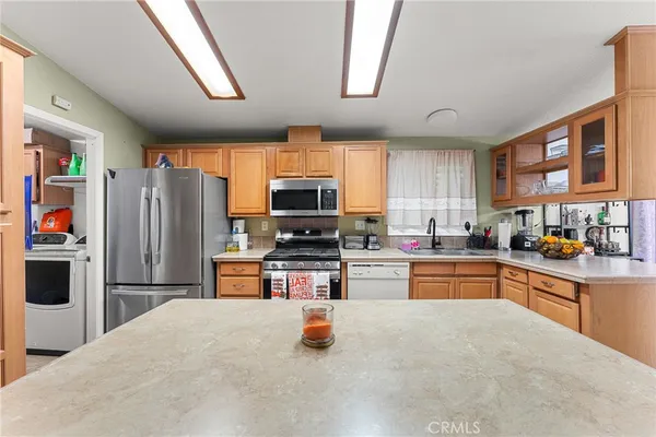 a kitchen with stainless steel appliances granite countertop a refrigerator stove and oven