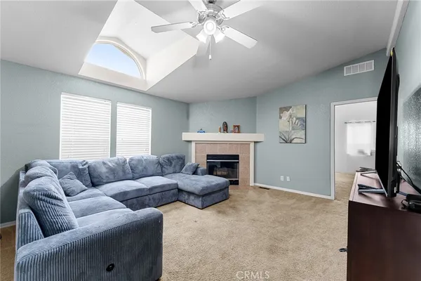 a living room with furniture a fireplace and a flat screen tv