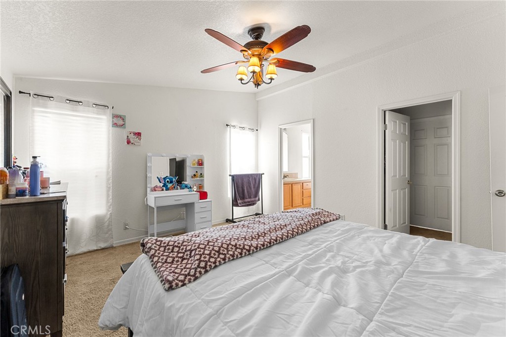 138 Sir Damas Drive Riverside, CA 92507 - Photo 25 of 36 a bedroom that has a bed and a chandelier