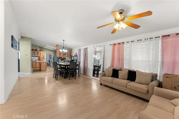 a living room with furniture and a dining table with kitchen view