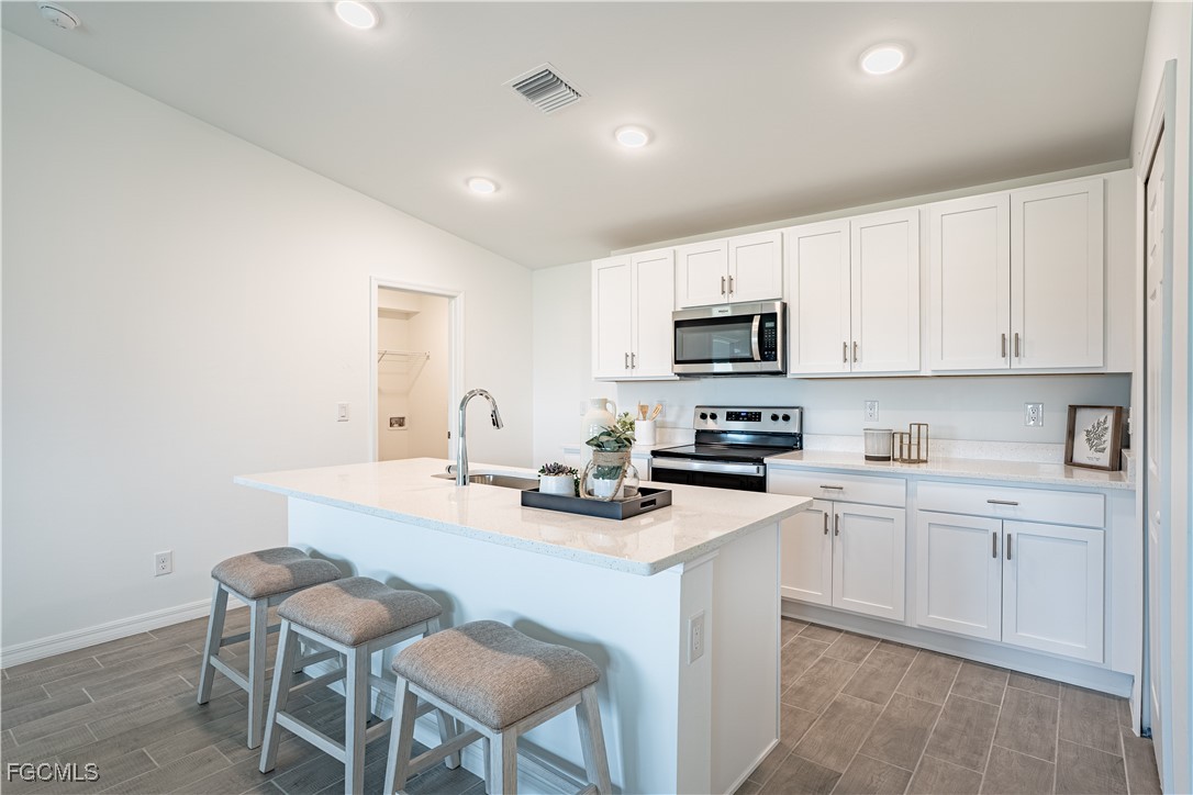 3216 17th Street West Lehigh Acres, FL 33971 - Photo 2 of 9 a kitchen with a sink cabinets and wooden floor