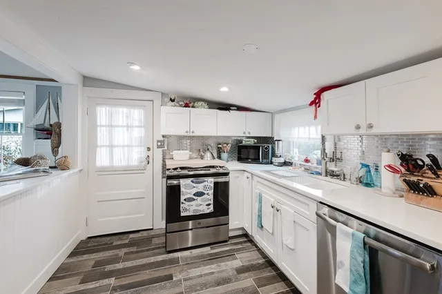 a kitchen that has a lot of cabinets a sink and appliances in it