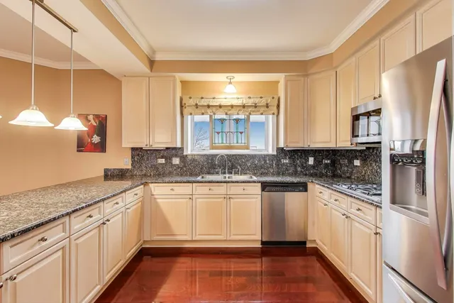 a kitchen with stainless steel appliances granite countertop a stove a sink and white cabinets