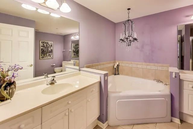 a bathroom with a tub sink and mirror
