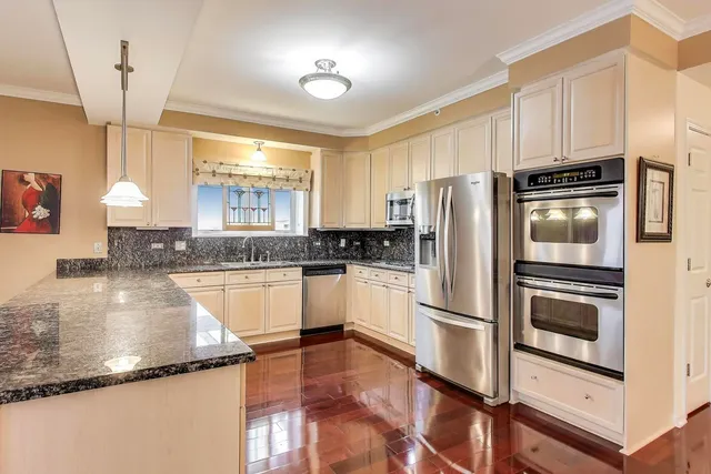 a kitchen with granite countertop a refrigerator oven a sink and dishwasher