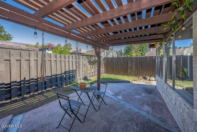 a view of a porch with chairs and potted plants