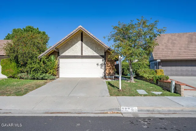 a view of a house with a tree and a yard