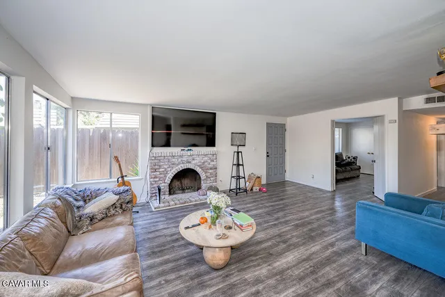 a living room with furniture a fireplace and a large window