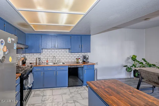 a kitchen with granite countertop a sink stove and wooden cabinets