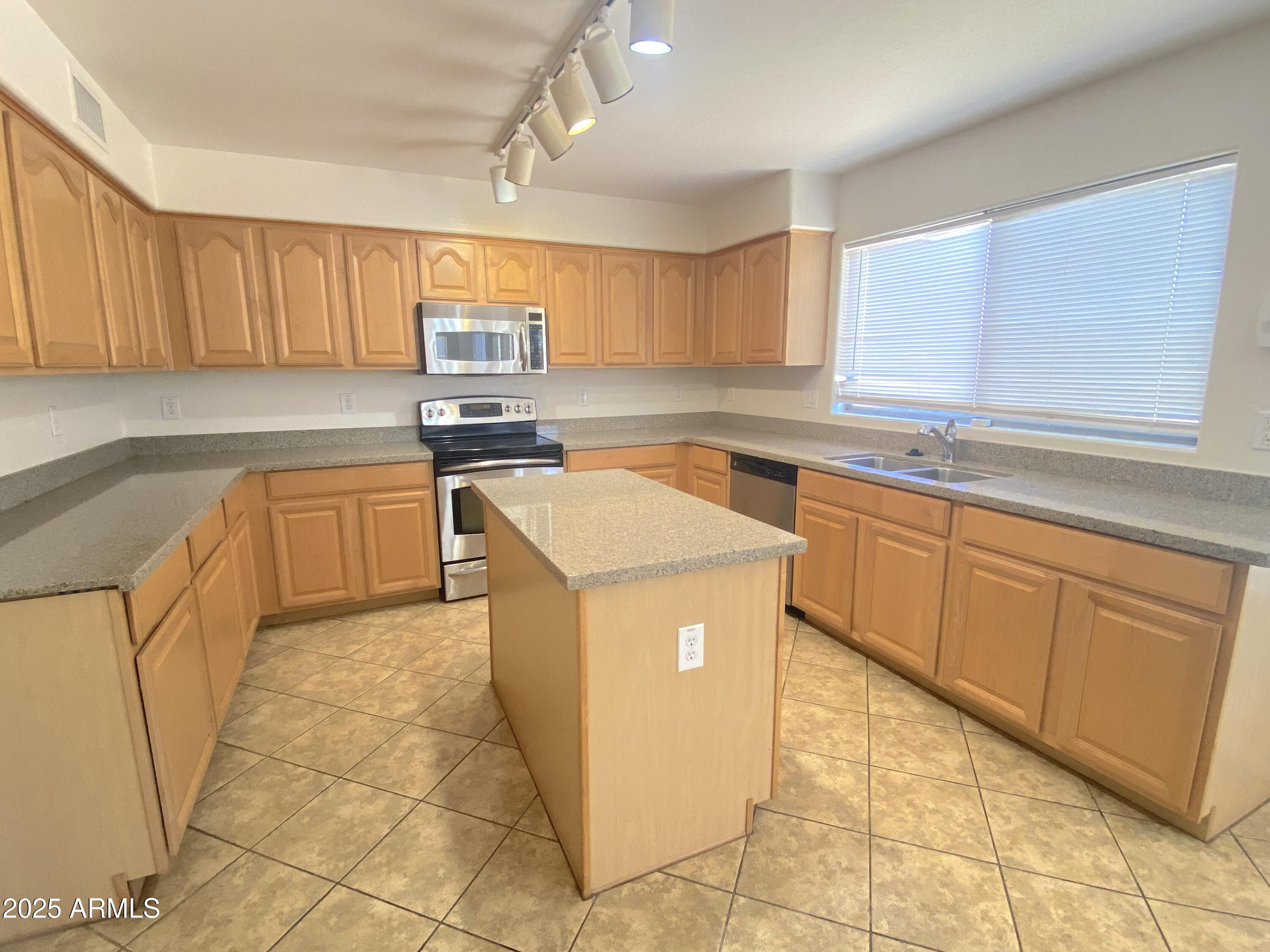 2036 West Quick Draw Way San Tan Valley, AZ 85144 - Photo 5 of 19 a kitchen with stainless steel appliances granite countertop a sink and cabinets