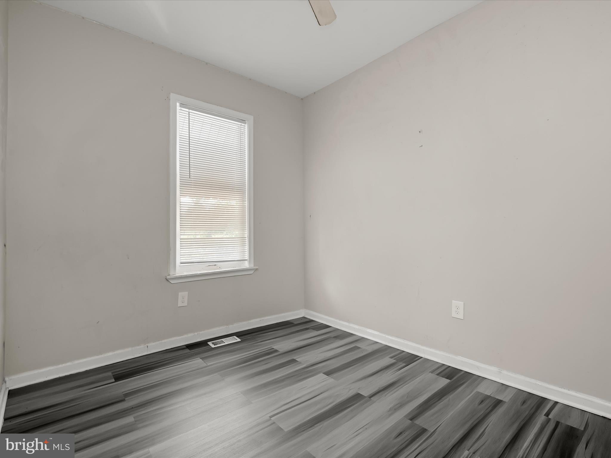 3018 Presstman Street Baltimore, MD 21216 - Photo 12 of 20 an empty room with wooden floor and windows