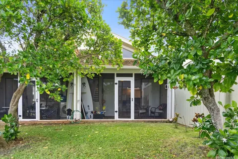 front view of a house with a big yard and large trees