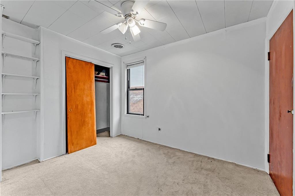 16 Spring Street Etna, PA 15223 - Photo 16 of 21 an empty room with a ceiling fan and a window