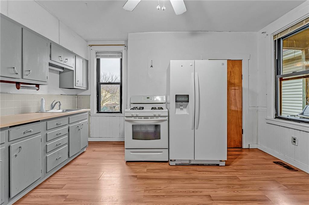16 Spring Street Etna, PA 15223 - Photo 9 of 21 a kitchen with stainless steel appliances white cabinets and wooden floors
