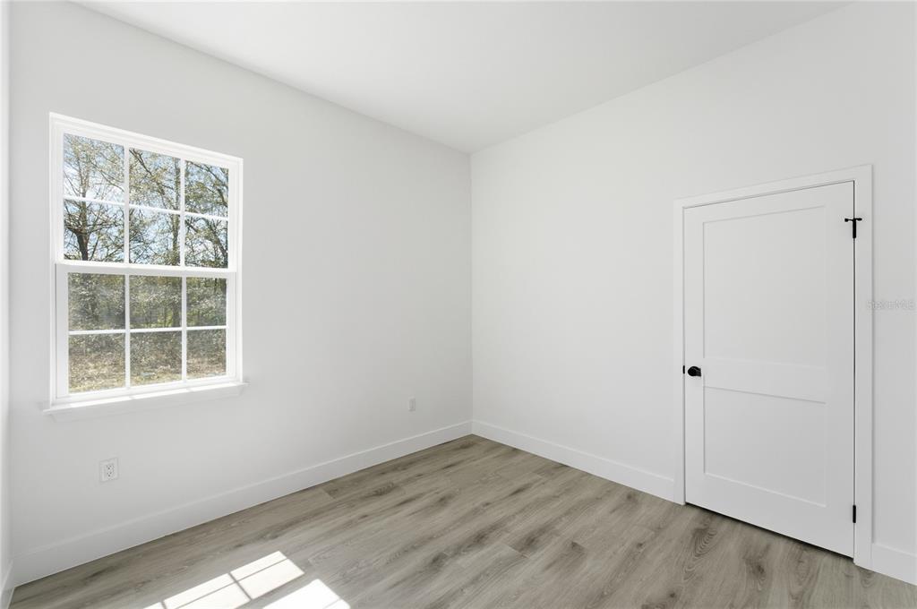 2600 Southwest 146th Pl Road Ocala, FL 34473 - Photo 19 of 40 an empty room with wooden floor and window