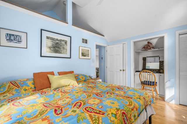 a bedroom with a bed and a painting on the wall