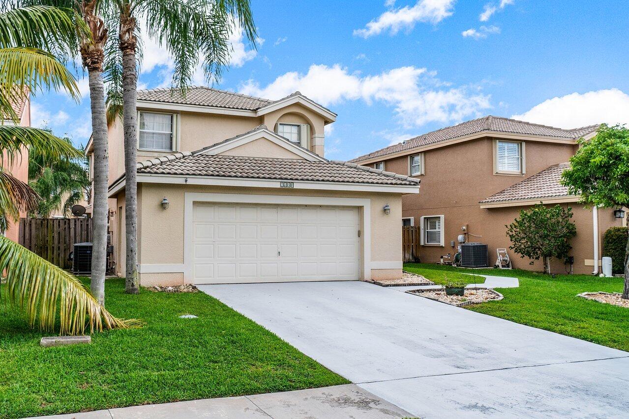 7250 Davit Circle Lake Worth, FL 33467 - Photo 2 of 35 a front view of a house with a yard and garage