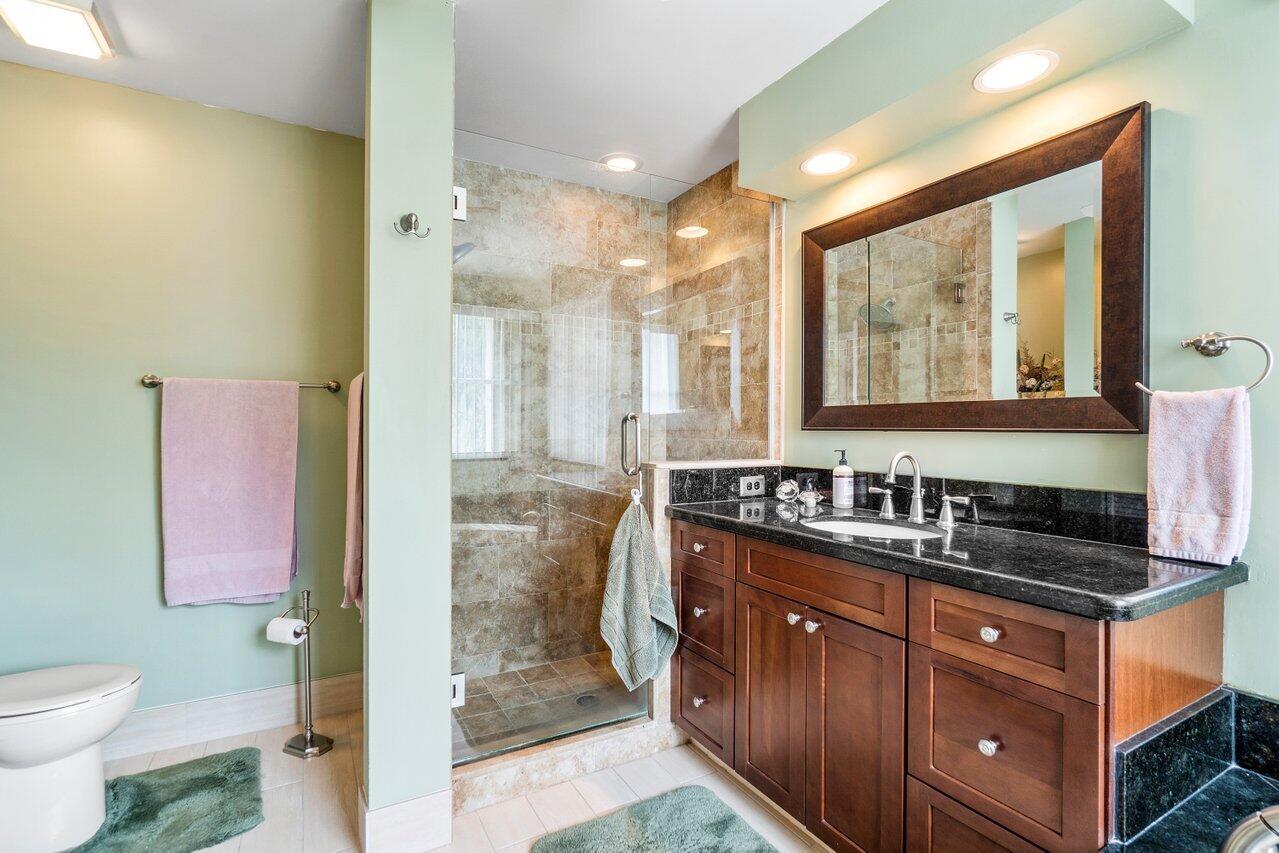 7250 Davit Circle Lake Worth, FL 33467 - Photo 21 of 35 a bathroom with a granite countertop sink a toilet a mirror and shower