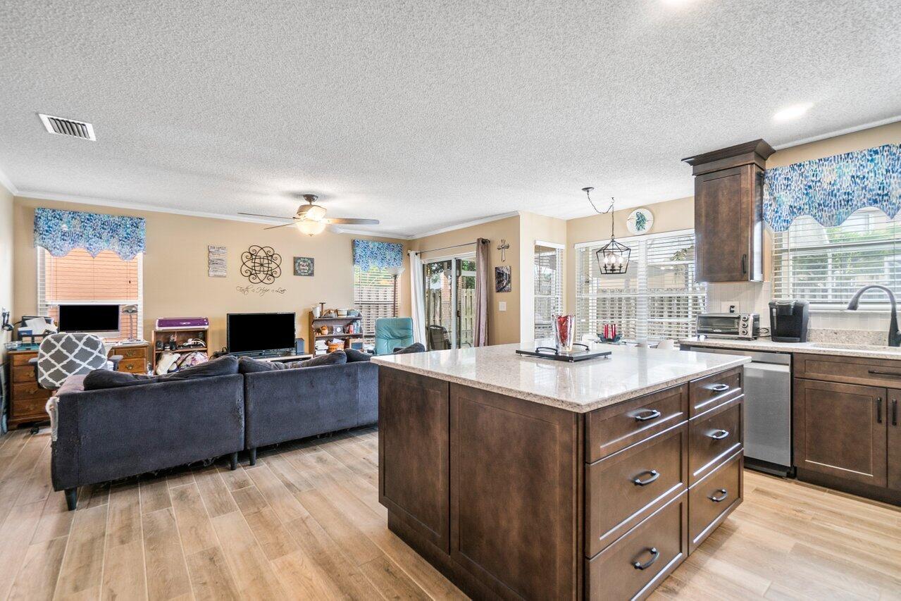 7250 Davit Circle Lake Worth, FL 33467 - Photo 9 of 35 a kitchen with kitchen island granite countertop a sink stove and cabinets