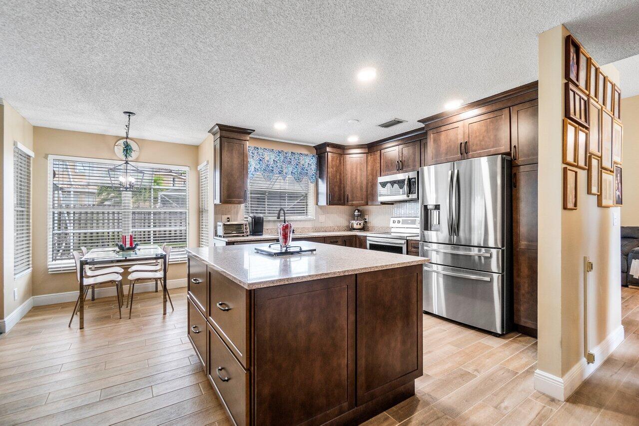 7250 Davit Circle Lake Worth, FL 33467 - Photo 10 of 35 a kitchen with stainless steel appliances granite countertop a sink stove and refrigerator