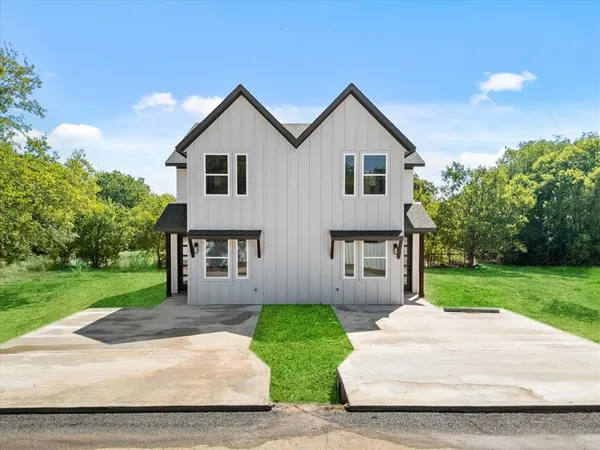 a front view of house with yard and green space