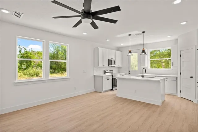 a kitchen with a white cabinets and chandelier