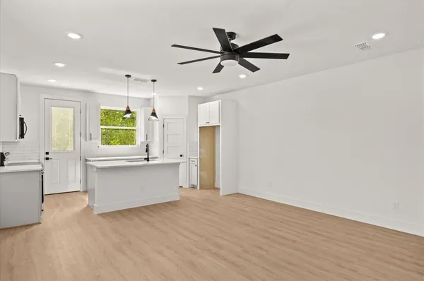 a view of a kitchen with wooden floor and a window