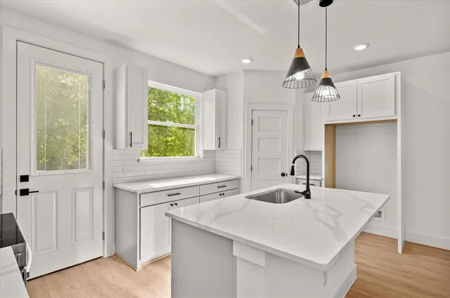 a kitchen with a sink center island with wooden floor