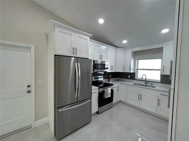 a kitchen with granite countertop stainless steel appliances and refrigerator