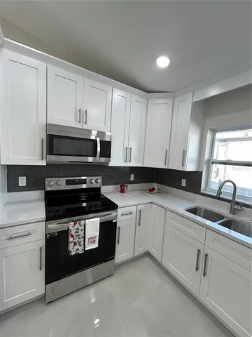a kitchen with cabinets appliances and a sink