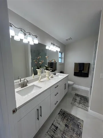 a spacious bathroom with a double vanity sink and a mirror