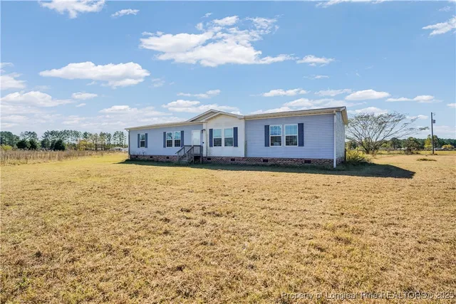 a view of a house with a yard and lake view