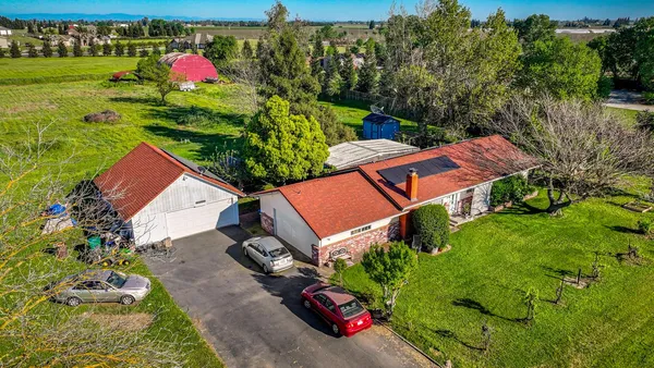 an aerial view of a house with garden space and street view