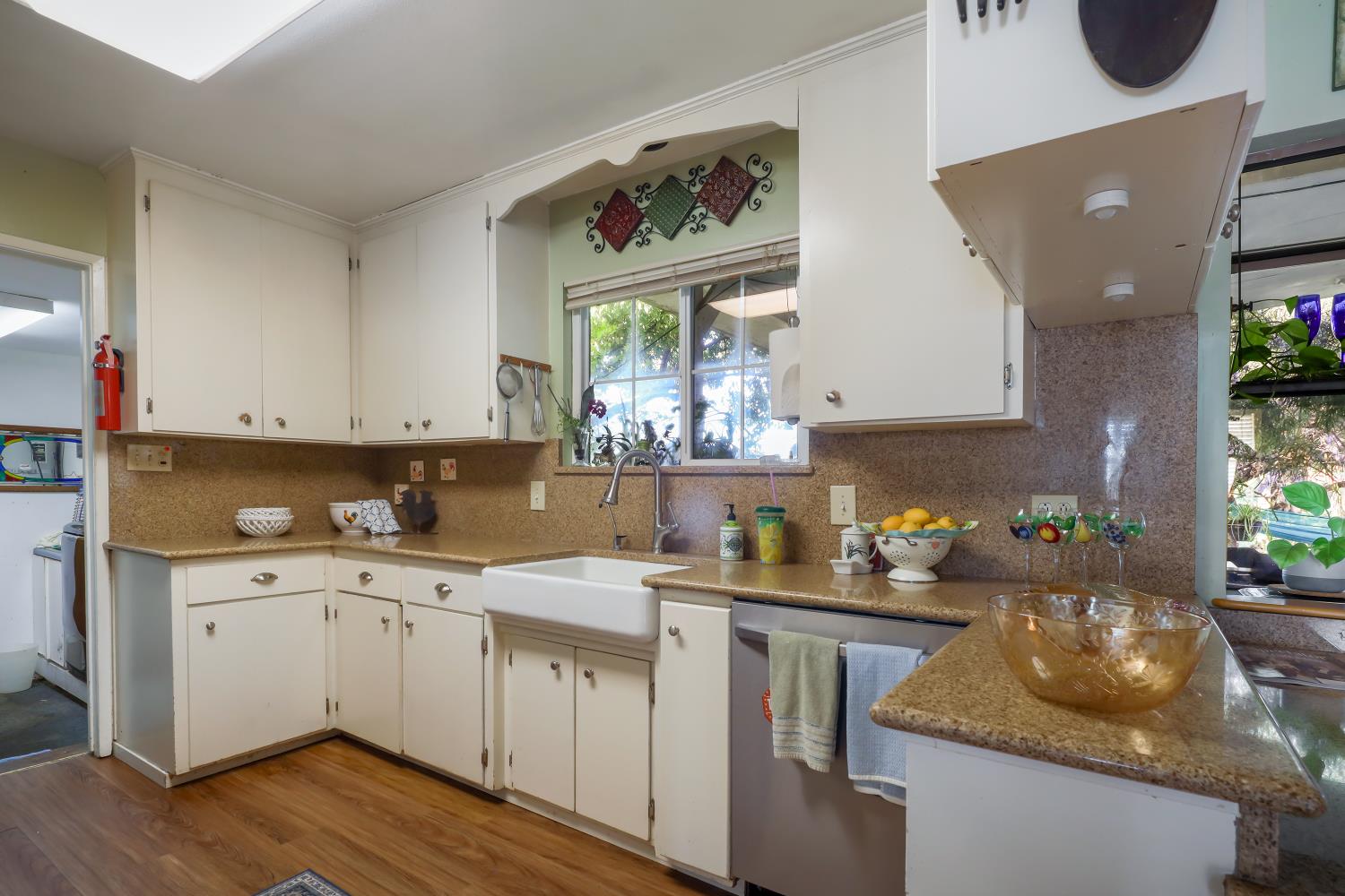 23404 Bruella Road Acampo, CA 95220 - Photo 36 of 69 a kitchen with a sink dishwasher a stove a dining table and chairs