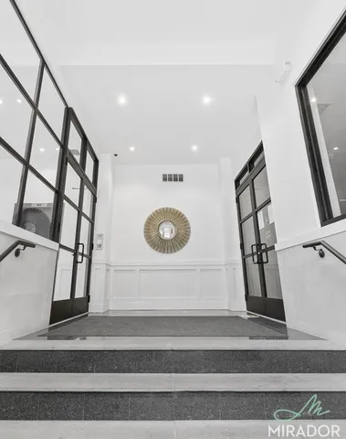 a view of staircase with white walls and a painting on the wall
