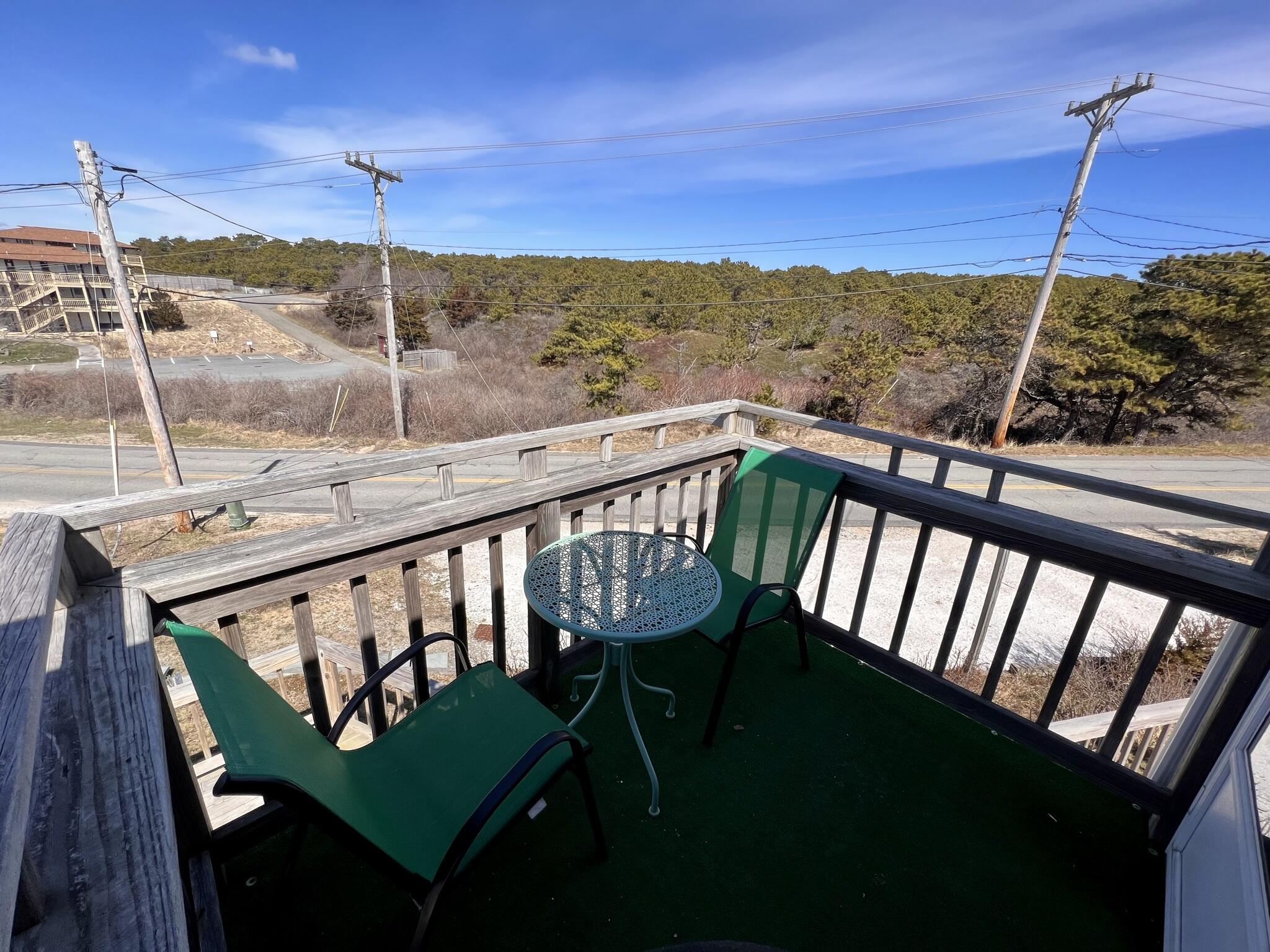168 Shore Road, Unit 3 Truro, MA 02666 - Photo 4 of 14 a view of a balcony with chair and wooden floor