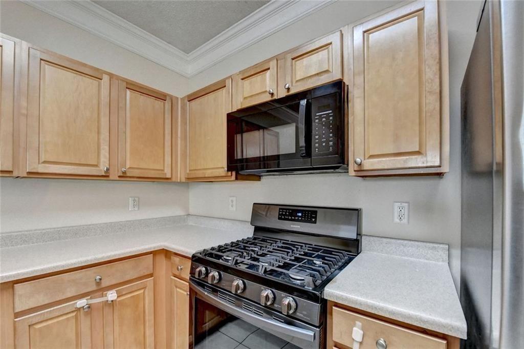 310 Azalea Circle Cumming, GA 30040 - Photo 13 of 38 a kitchen with wooden cabinets and a stove top oven