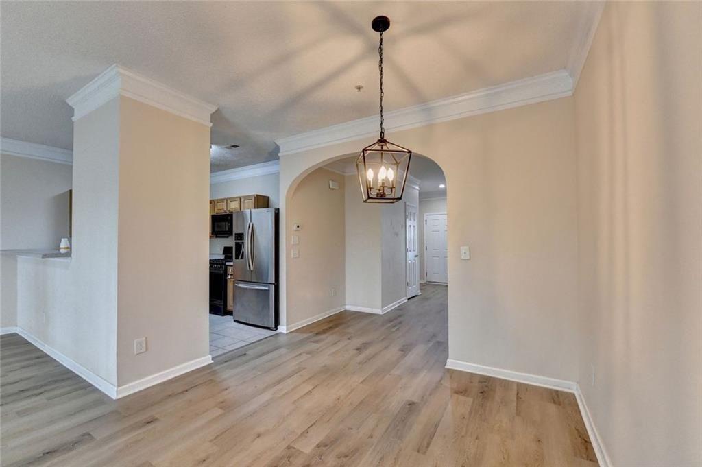 310 Azalea Circle Cumming, GA 30040 - Photo 10 of 38 a view of a hallway with wooden floor and a chandelier