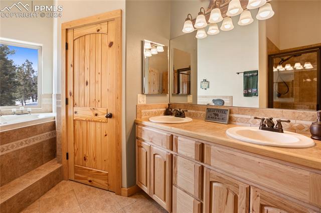 156 Paradiso Road Divide, CO 80814 - Photo 31 of 45 Bathroom with separate shower soaking bathtub, double vanity, and tile floors