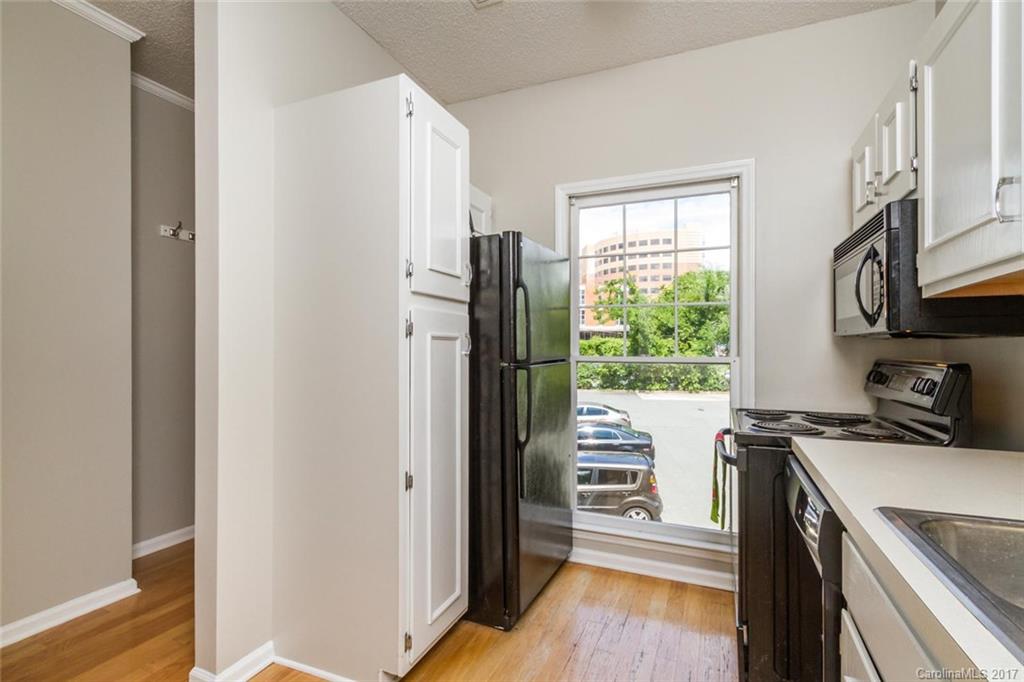 301 Queens Road, Unit 201 Charlotte, NC 28204 - Photo 8 of 24 a kitchen with a refrigerator stove and wooden floor