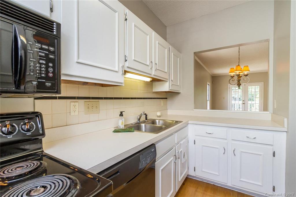 301 Queens Road, Unit 201 Charlotte, NC 28204 - Photo 9 of 24 a kitchen with a sink a stove and cabinets