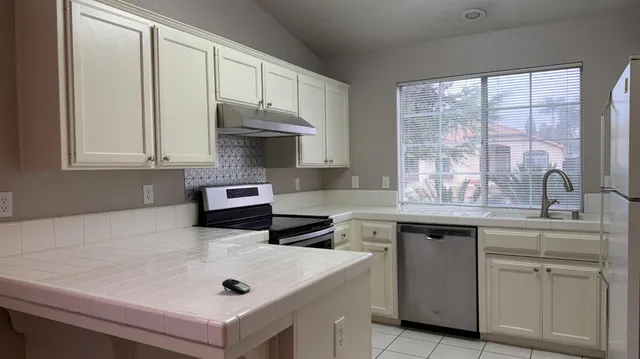 a kitchen with white cabinets and white appliances