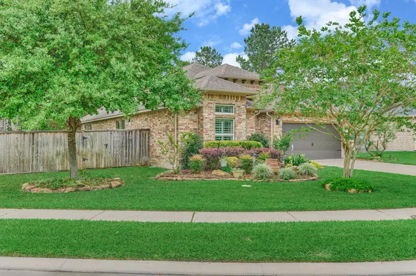 a front view of a house with a yard and green space