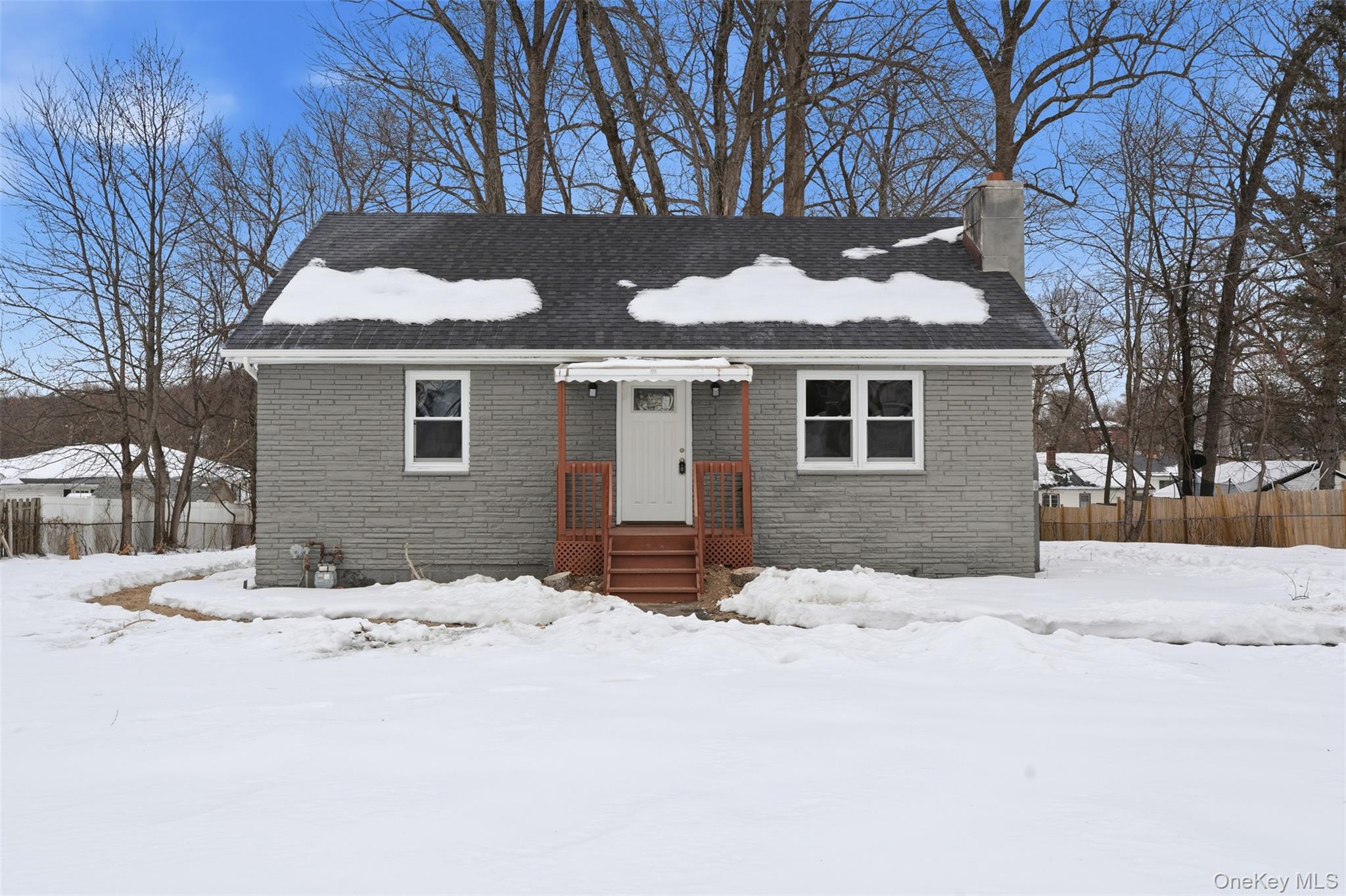 a front view of house with a yard covered in snow