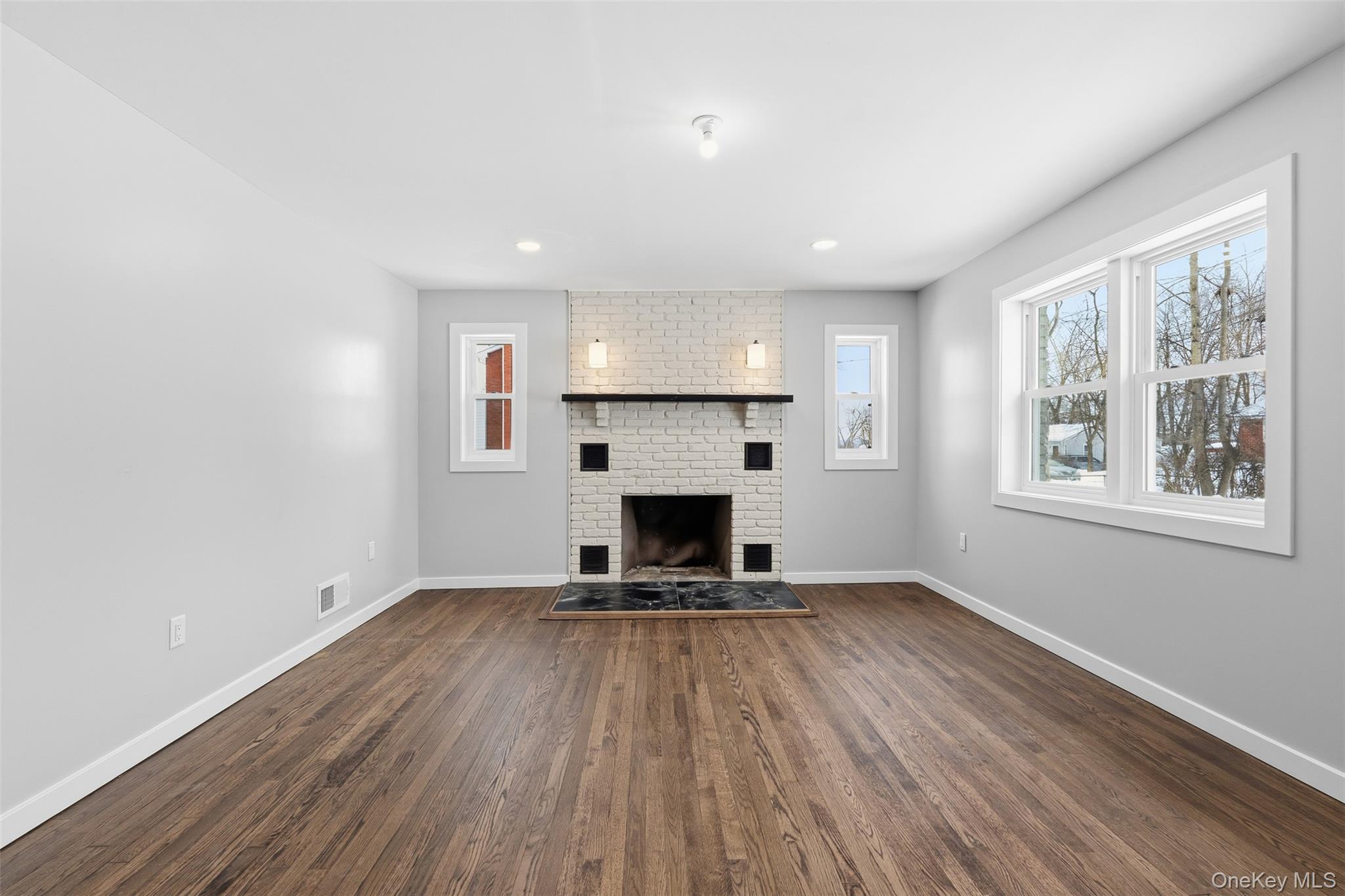 21 Janet Place Stony Point, NY 10980 - Photo 6 of 31 an empty room with windows a fireplace and wooden floor